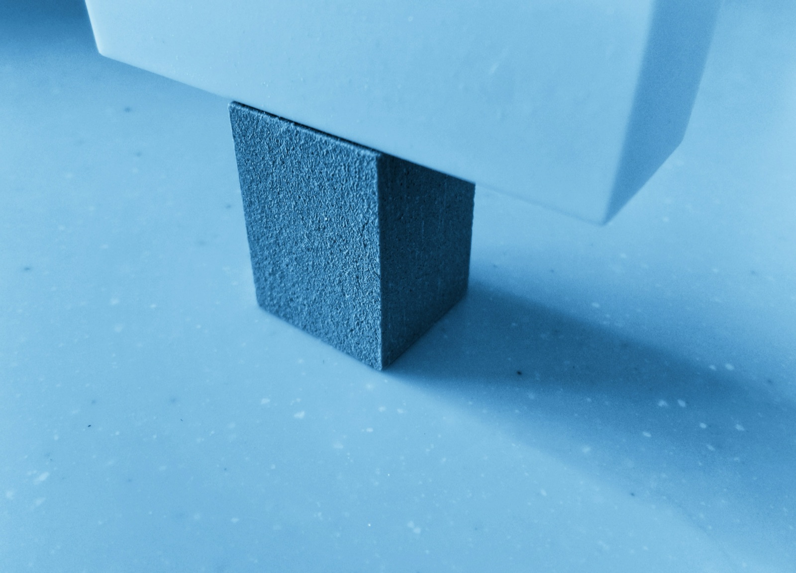 Blue elastomeric vibration isolation block supporting a load for Pyra-Sil™ RTV silicone vibration and shock dampening