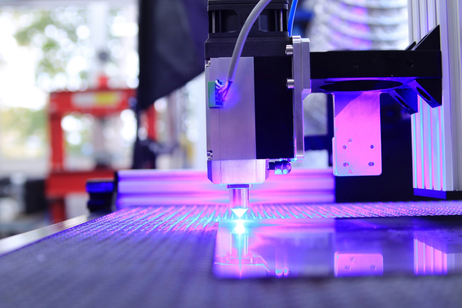 Purple UV curing beam from industrial CNC head for Incure F-Series™ UV flood lamp optical bonding