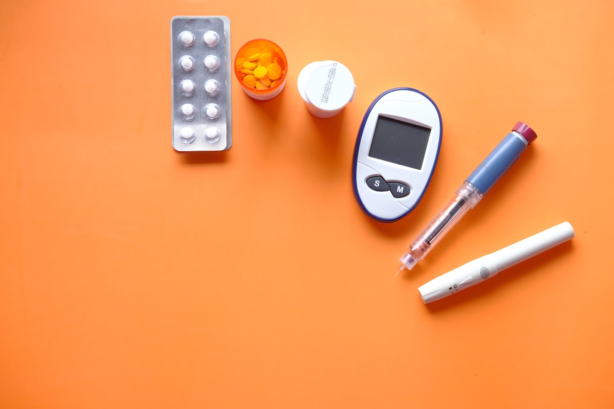Insulin pen and diabetic diagnostic devices on orange background for Cyro-Weld™ UV medical adhesive glucose monitor
